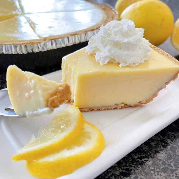 A slice of lemon icebox pie topped with whipped cream.