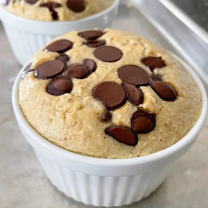 Baked oats with chocolate chips in a white ramekin.