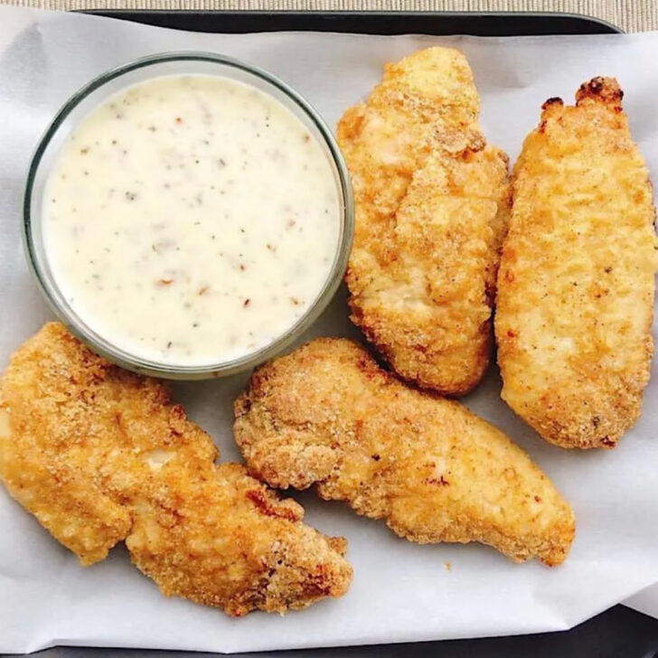 Oven fried chicken with a side of garlic parmesan sauce.