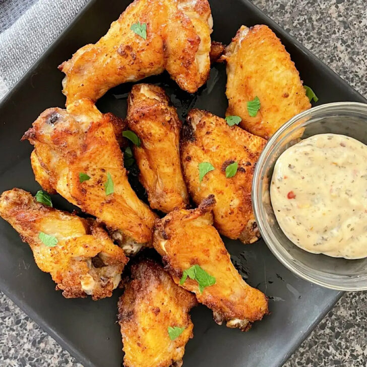 Air fryer chicken wings on a brown plate.