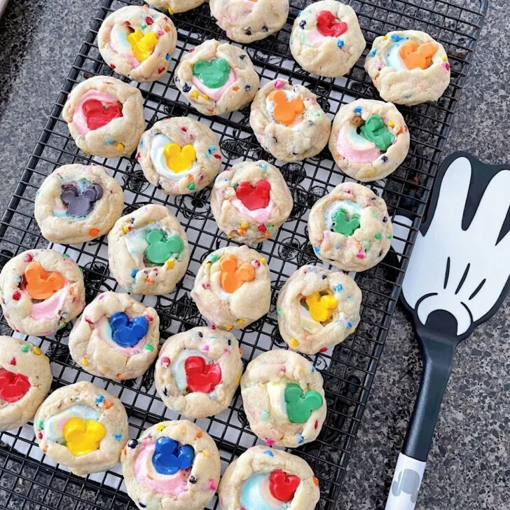 Rainbow chip cookies on a cooling rack.