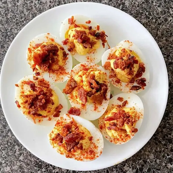 Crack deviled eggs on a white plate.