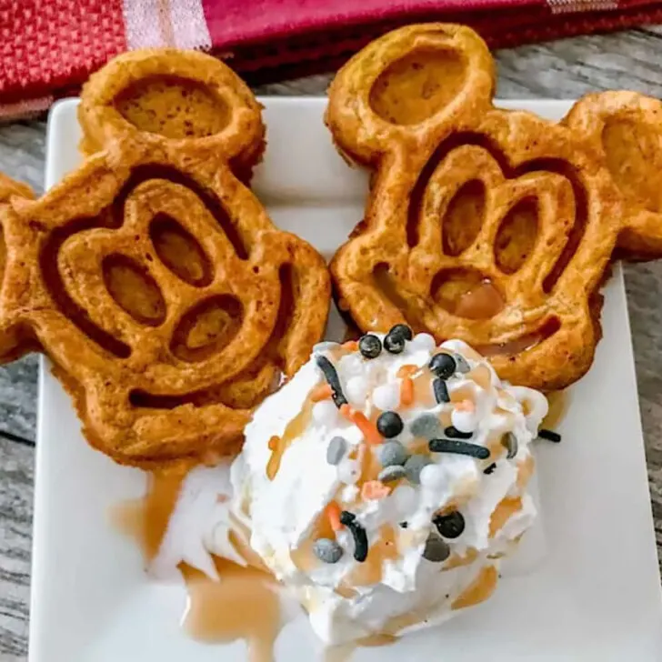Two pumpkin Mickey waffles with a scoop of ice cream.