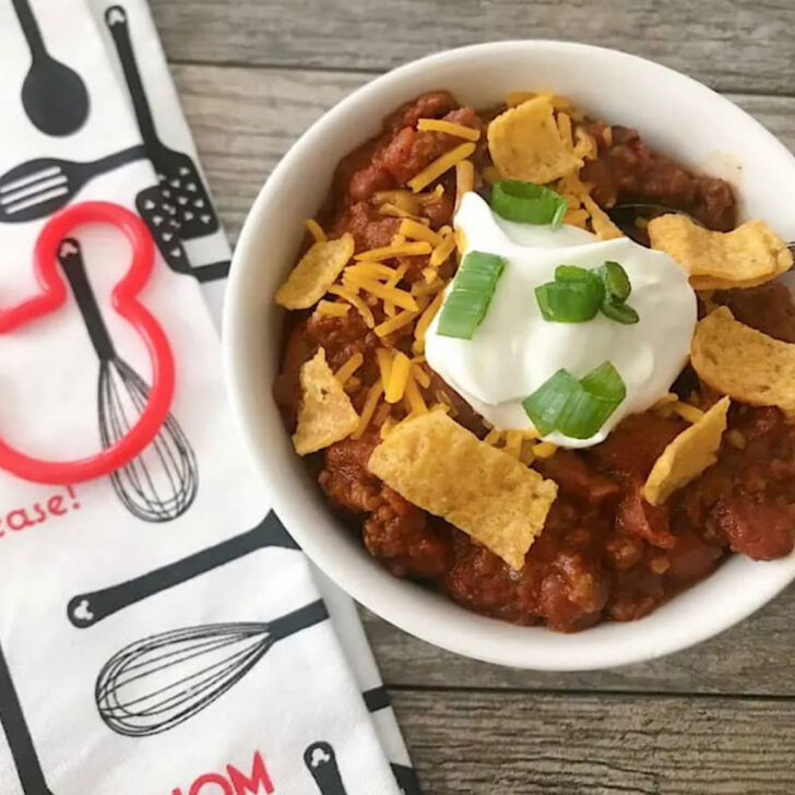 A bowl of Disney World Chili with sour cream and Fritos.