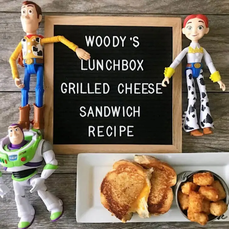 Woody, Buzz Lightyear, and Jessie with a Toy Story Land Grilled Cheese Sandwich and a sign that says 