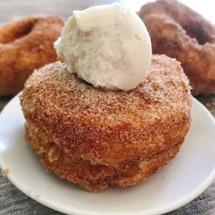 A homemade cronut topped with ice cream.