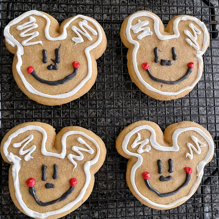 Four gingerbread sugar cookies decorated like Mickey Mouse.