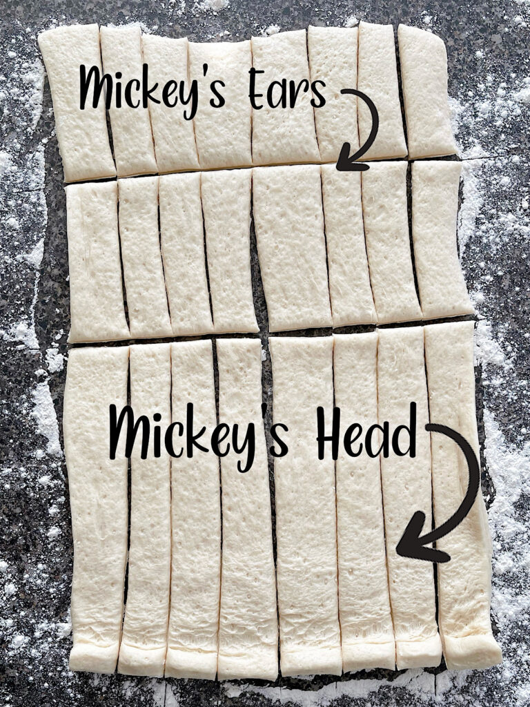 Pizza dough cut into strips to make Mickey Mouse shapes.
