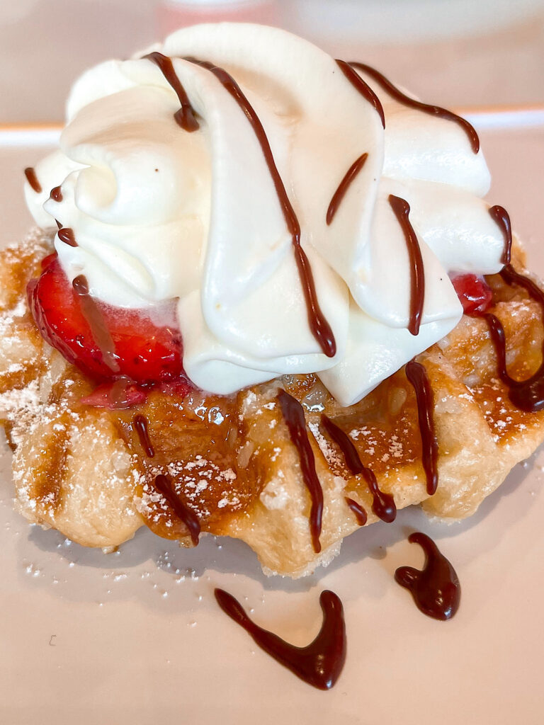 A leige waffle with strawberries and whipped cream from Connections Eatery at Epcot.