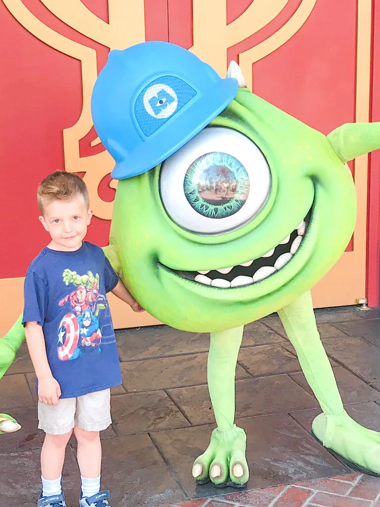 A child with a Monsters Inc. character at Disneyland.