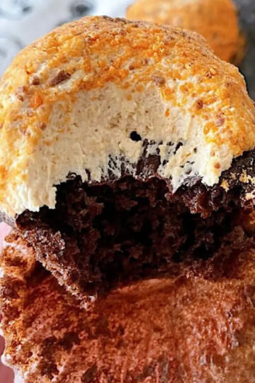 A chocolate cupcake, filled with ganache and topped with peanut butter buttercream frosting and Butterfinger crumbs.