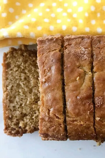 A loaf of banana bread made with sour cream cut into slices.