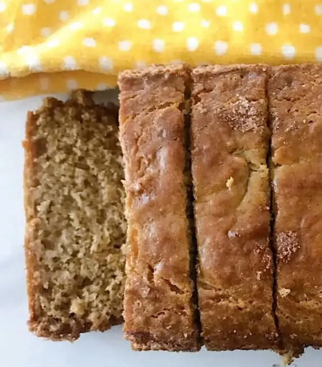 A loaf of banana bread made with sour cream cut into slices.