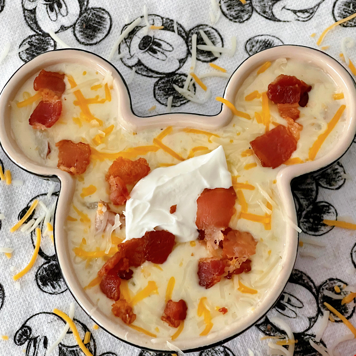 Disneyland's Loaded Baked Potato Soup in a Mickey Mouse-shaped bowl with sour cream and bacon.