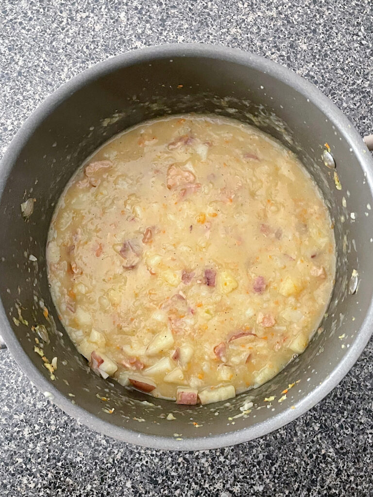 Loaded Baked Potato Soup on a soup pot.