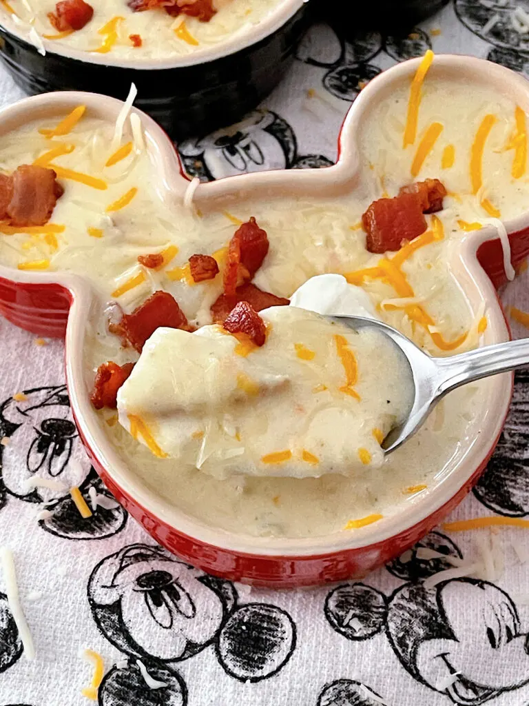 Disneyland's Loaded Baked Potato Soup in a Mickey Mouse-shaped bowl with sour cream and bacon.