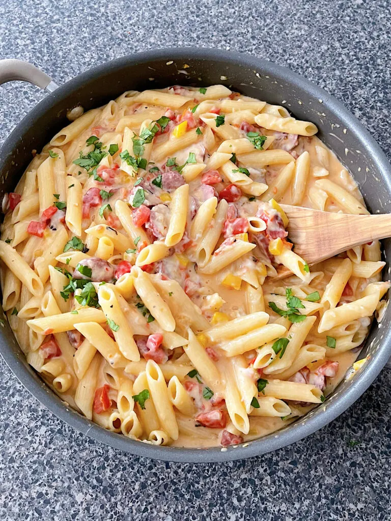 Spicy sausage pasta in a sauce pan.