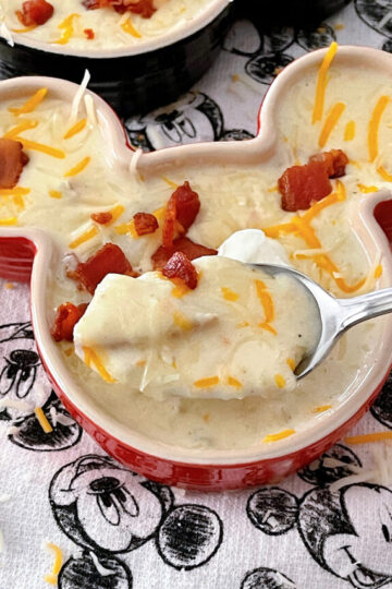 Disneyland's Loaded Baked Potato Soup in a Mickey Mouse-shaped bowl with sour cream and bacon.