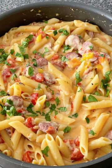 Spicy sausage pasta in a sauce pan.