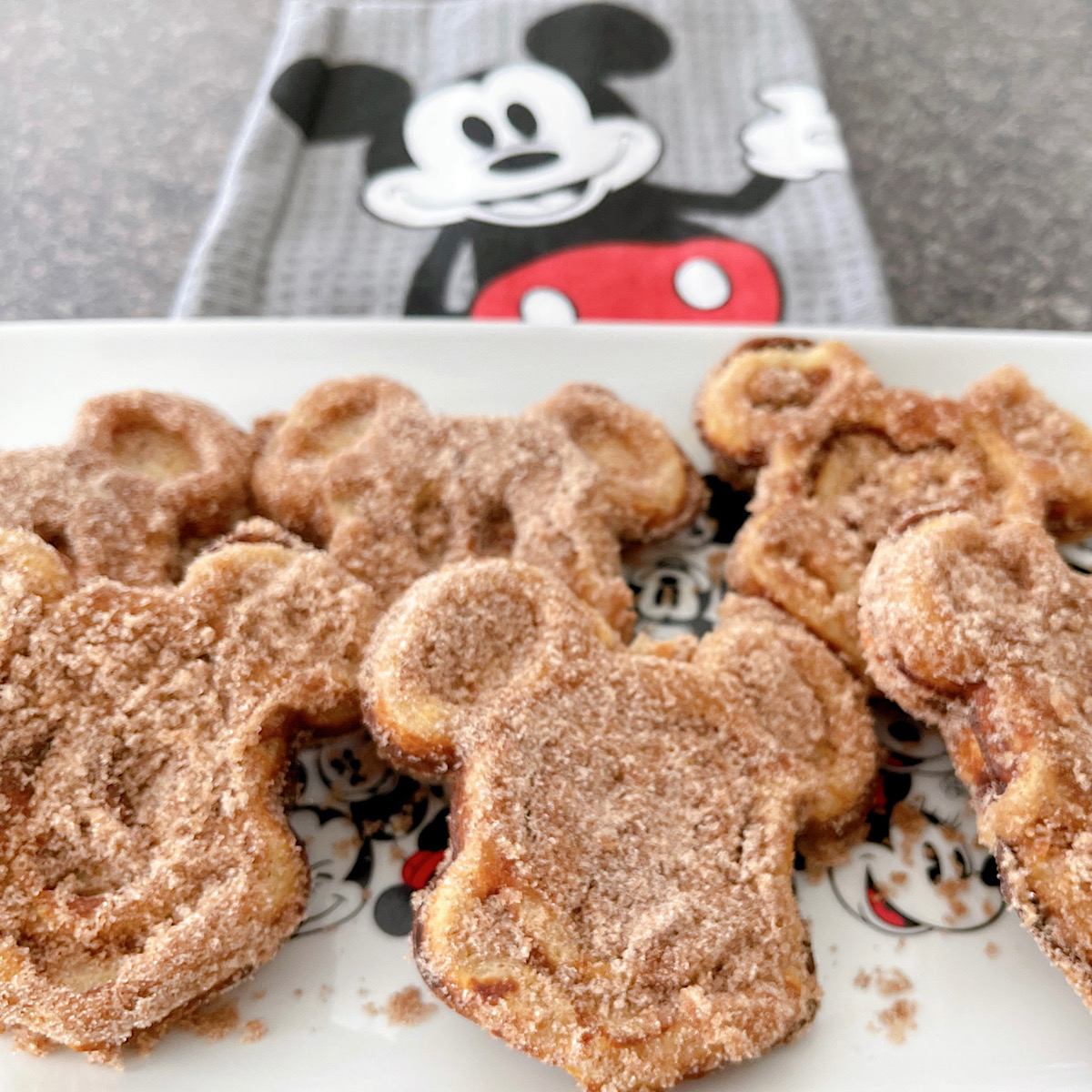 Mickey waffles made with churro dough and covered in cinnamon sugar.