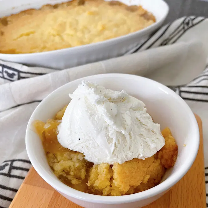 Peach cobbler in a bowl and in a dish with vanilla ice cream.