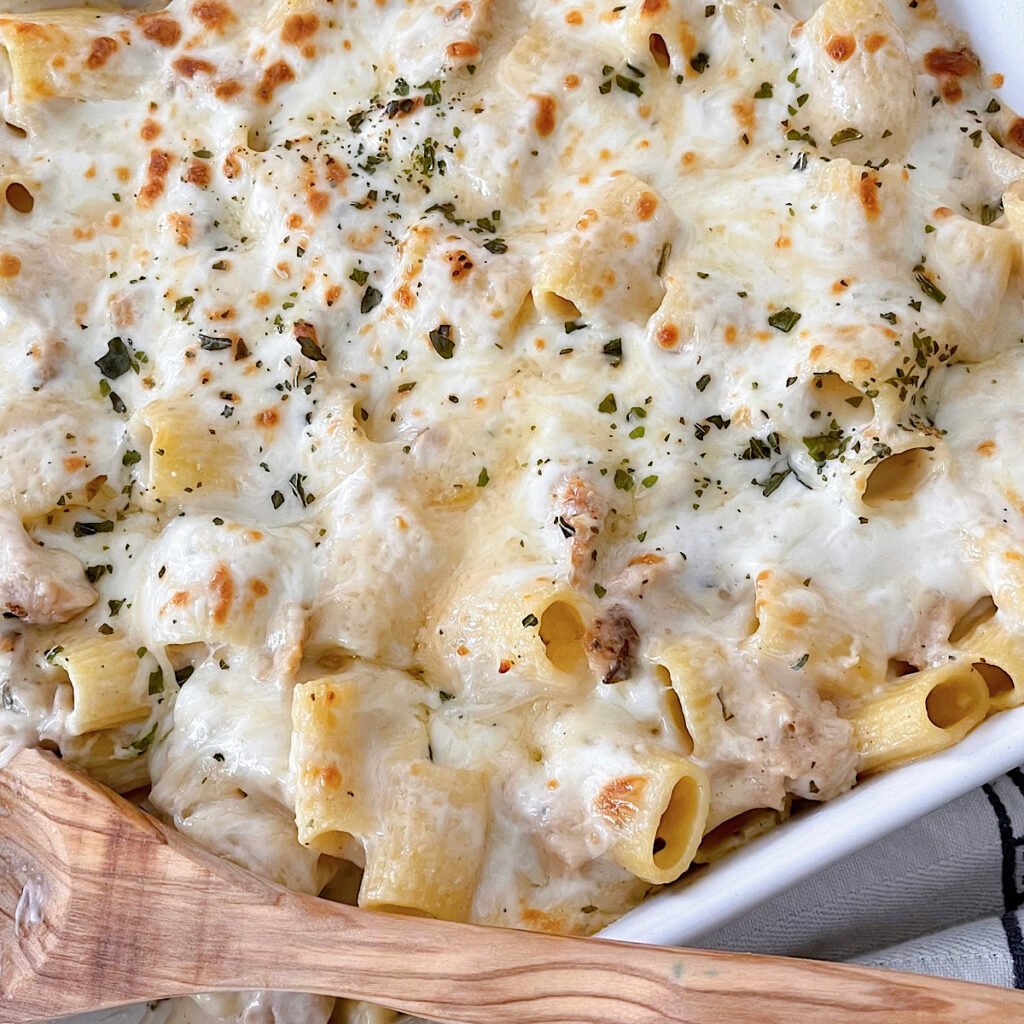 A dish of baked Garlic Parmesan Chicken Alfredo pasta.