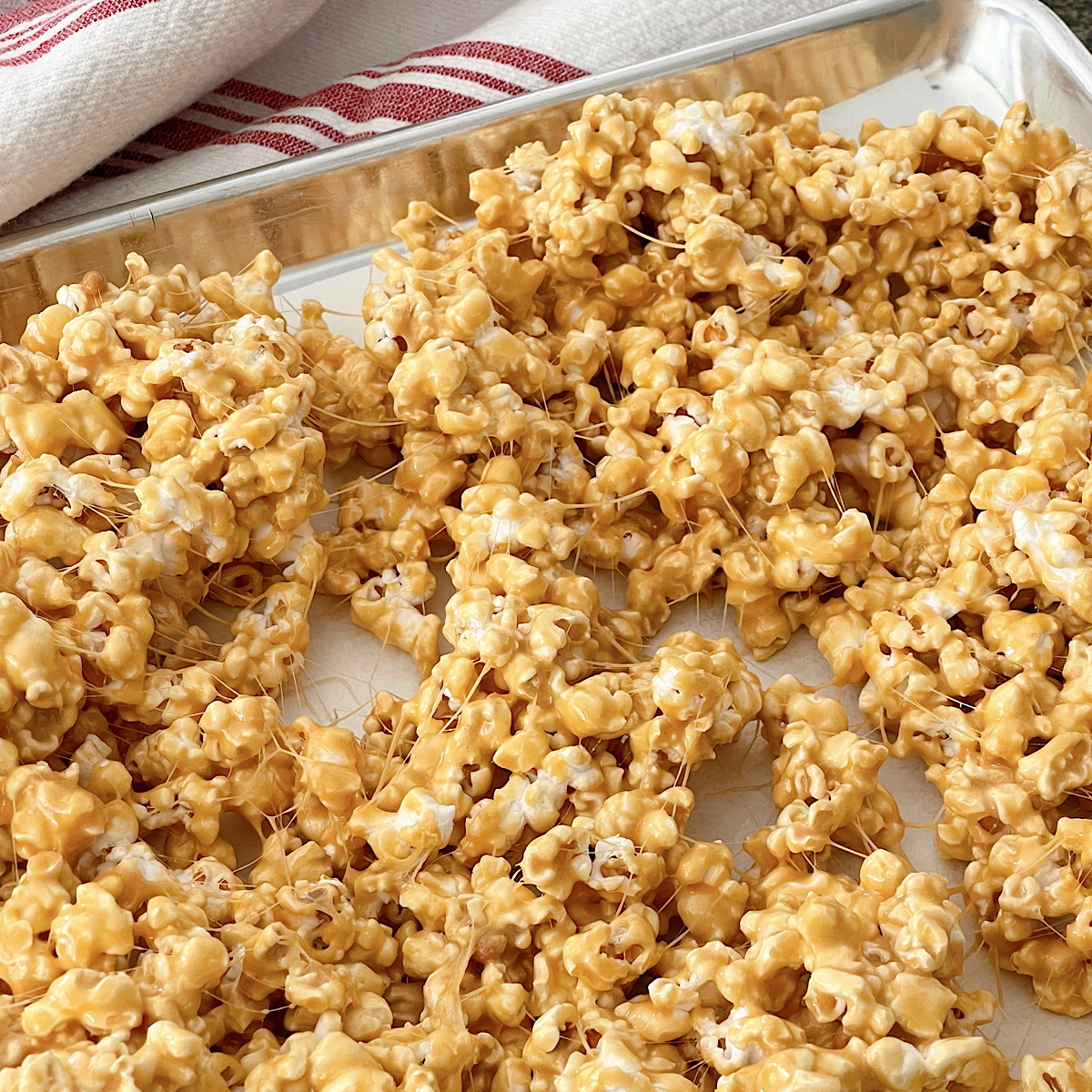 Marshmallow caramel popcorn on a baking sheet.