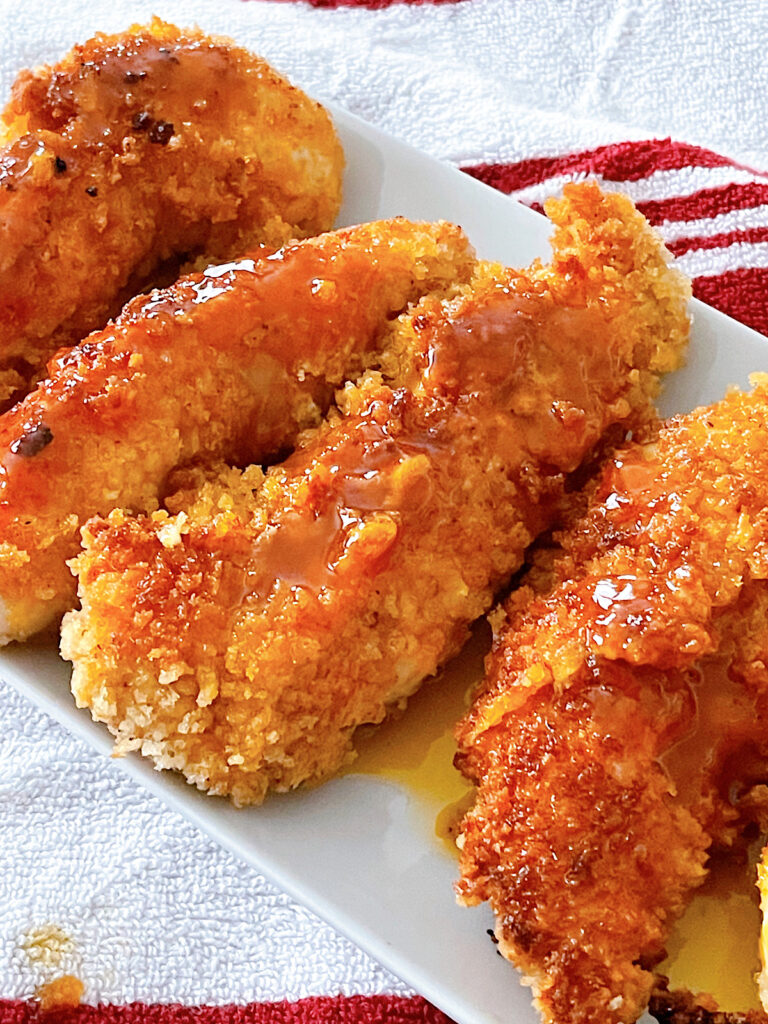 Hot honey chicken tenders on a white plate.