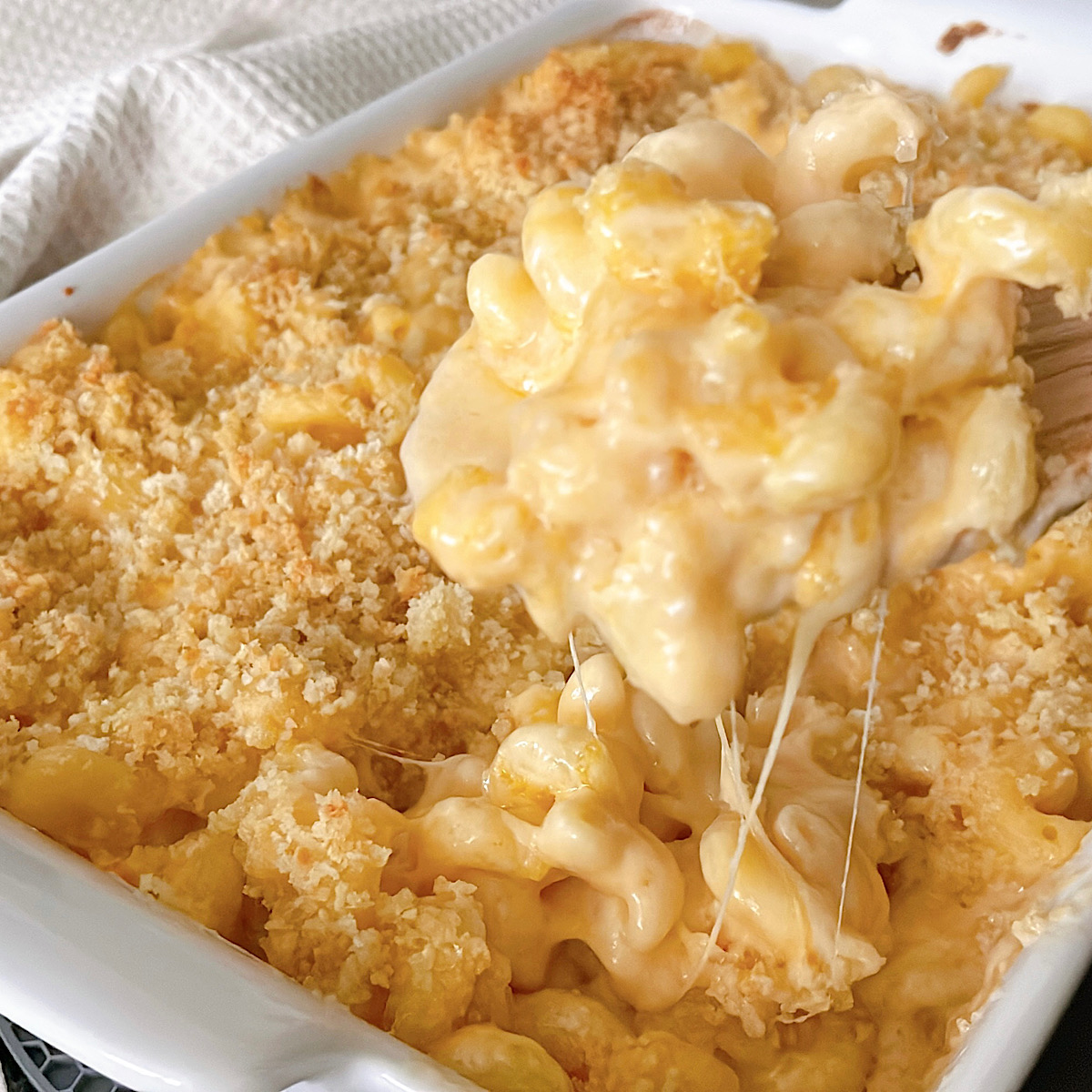 Homemade baked mac and cheese on a wooden spoon.
