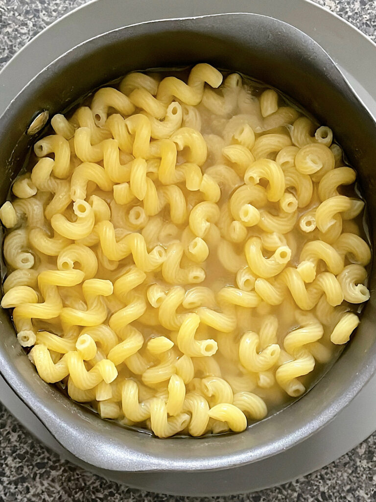 Cavatappi pasta in a pot of water.