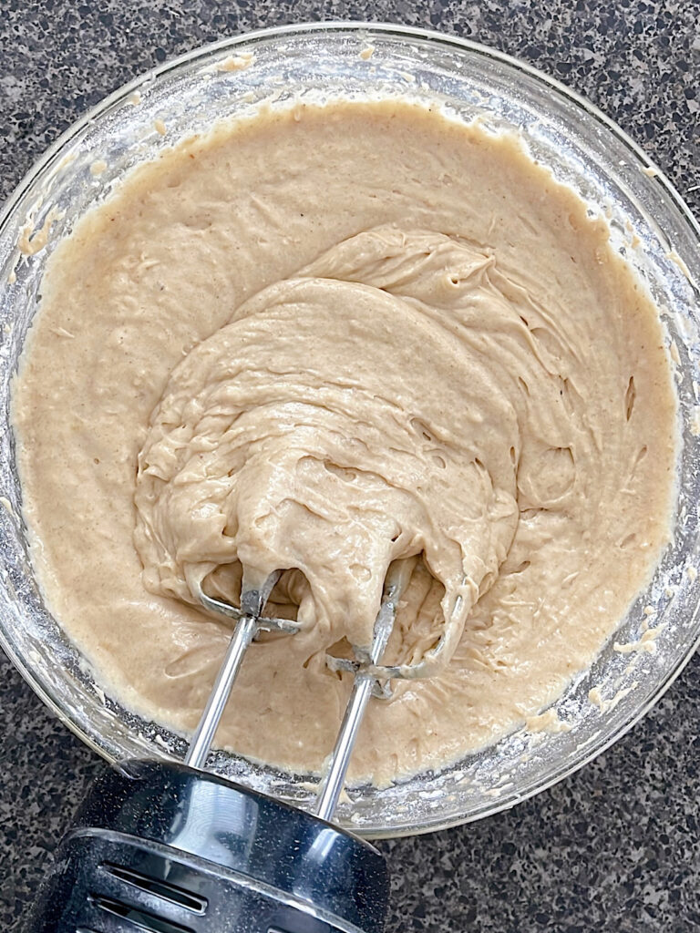 Sourdough banana bread batter in a mixing bowl with and electric mixer.
