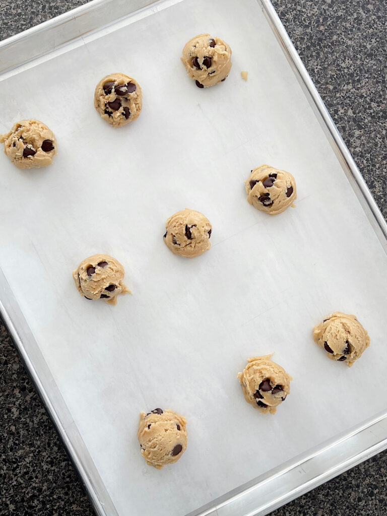 Cookie dough balls on a baking sheet.