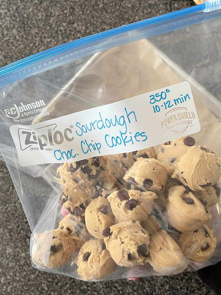 Frozen sourdough chocolate chip cookie dough balls in a freezer bag.