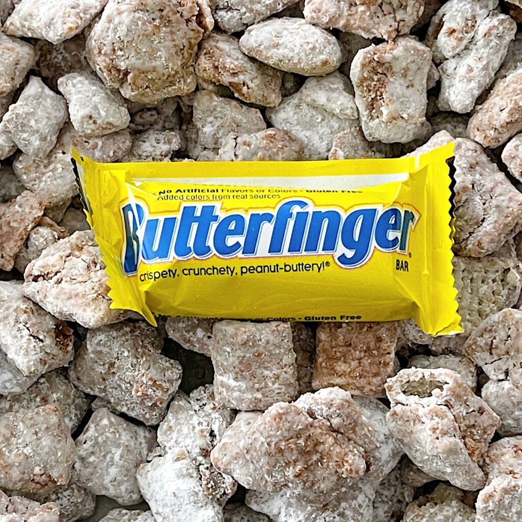 Muddy Buddies made with Butterfinger crumbs with a small Butterfinger candy bar.