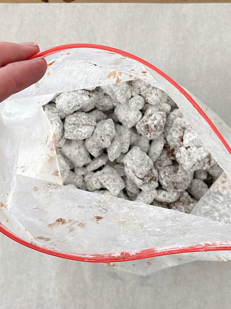 Muddy Buddies covered in powdered sugar in a ziplock bag.