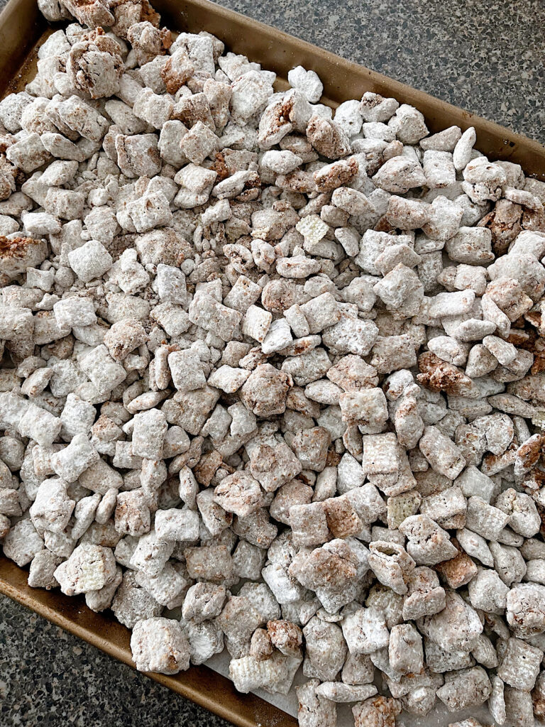 Butterfinger Muddy Buddies on a baking sheet.