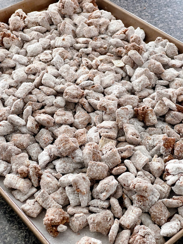 Butterfinger Muddy Buddies on a baking sheet.