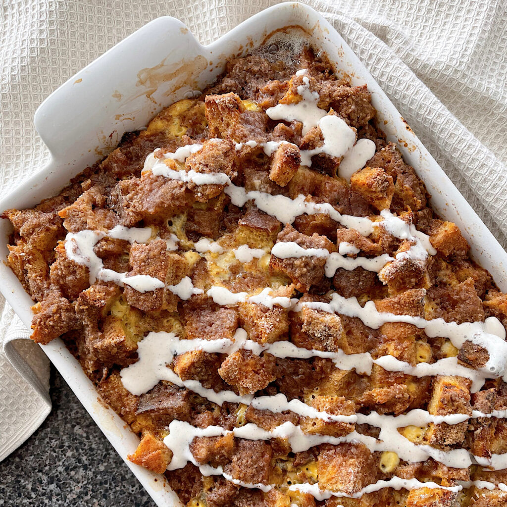 Cinnamon Crunch French Toast casserole drizzled with cinnamon cream cheese syrup.