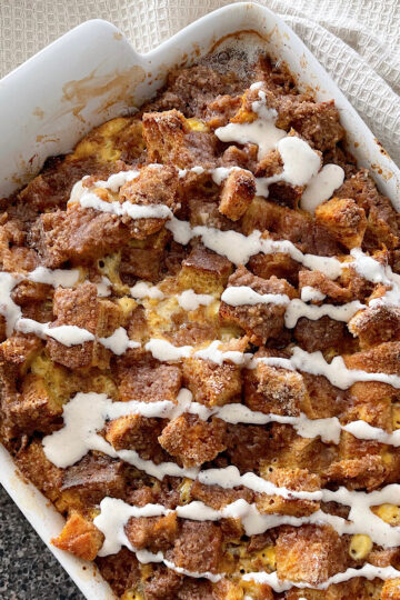 Cinnamon Crunch French Toast casserole drizzled with cinnamon cream cheese syrup.