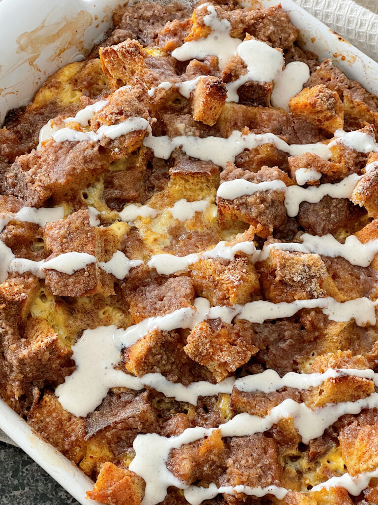 Cinnamon Crunch French Toast casserole drizzled with cinnamon cream cheese syrup.