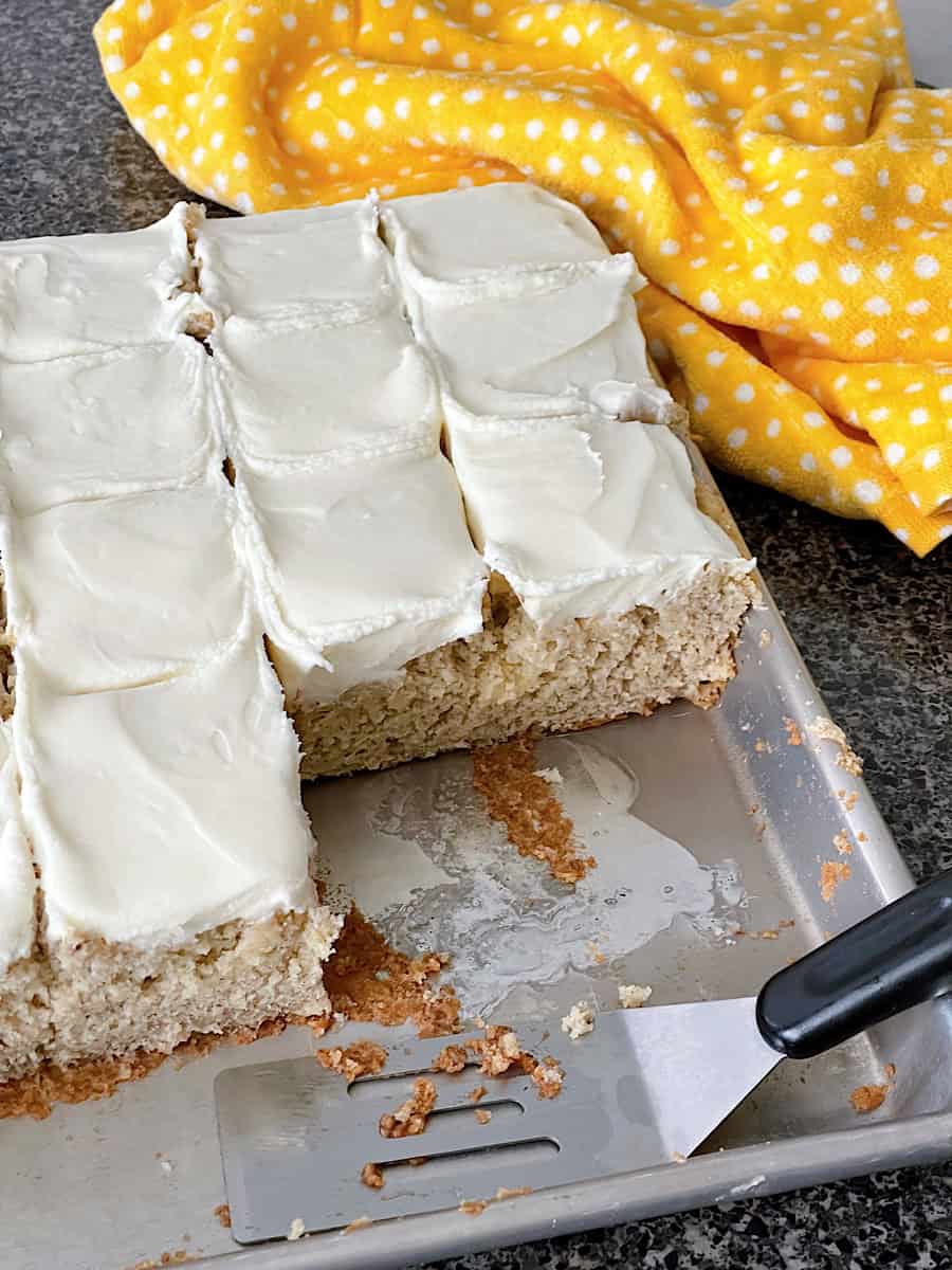 Frosted banana bread bars on a baking sheet.