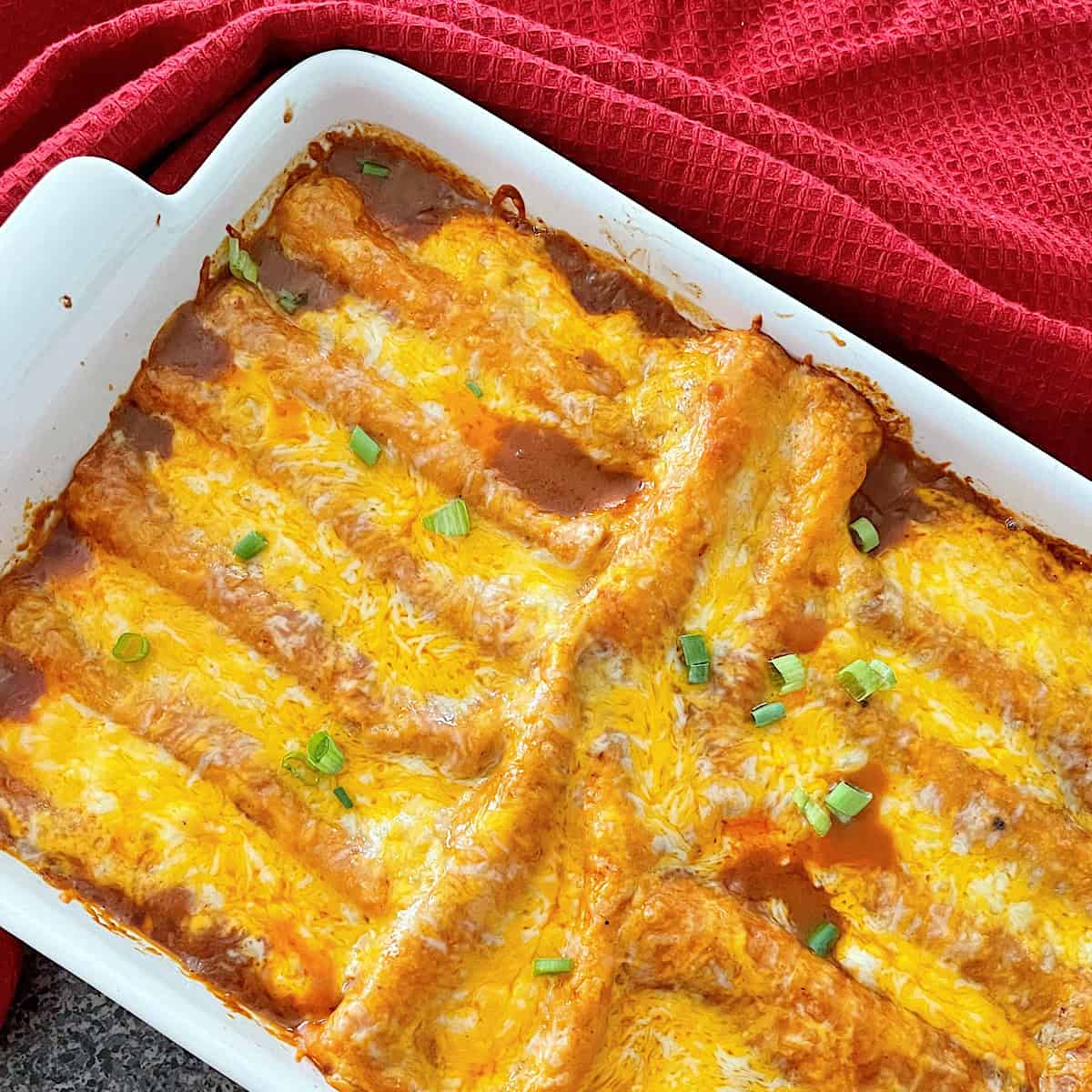 Restaurant-style cheese enchiladas in a white dish.