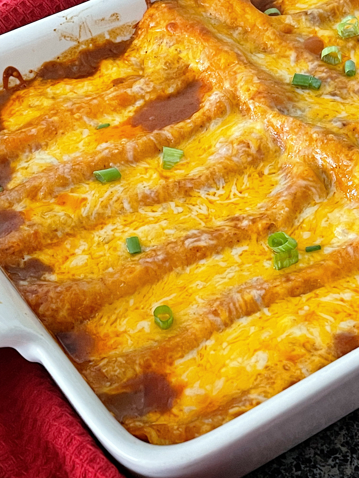 Restaurant-style cheese enchiladas in a white dish.
