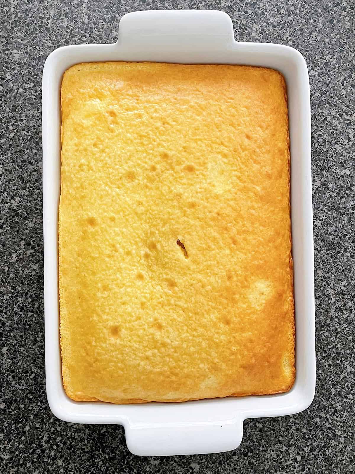 A vanilla cake in a white dish.