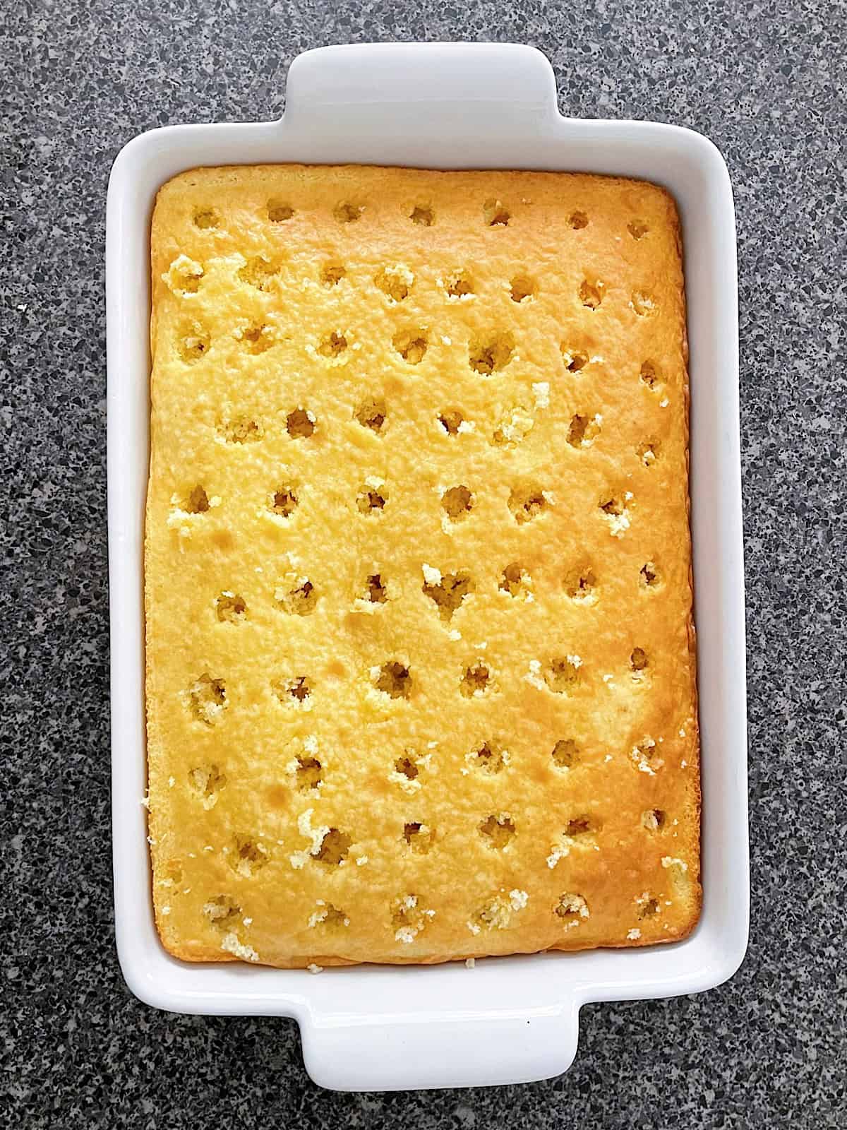 A vanilla cake with holes.