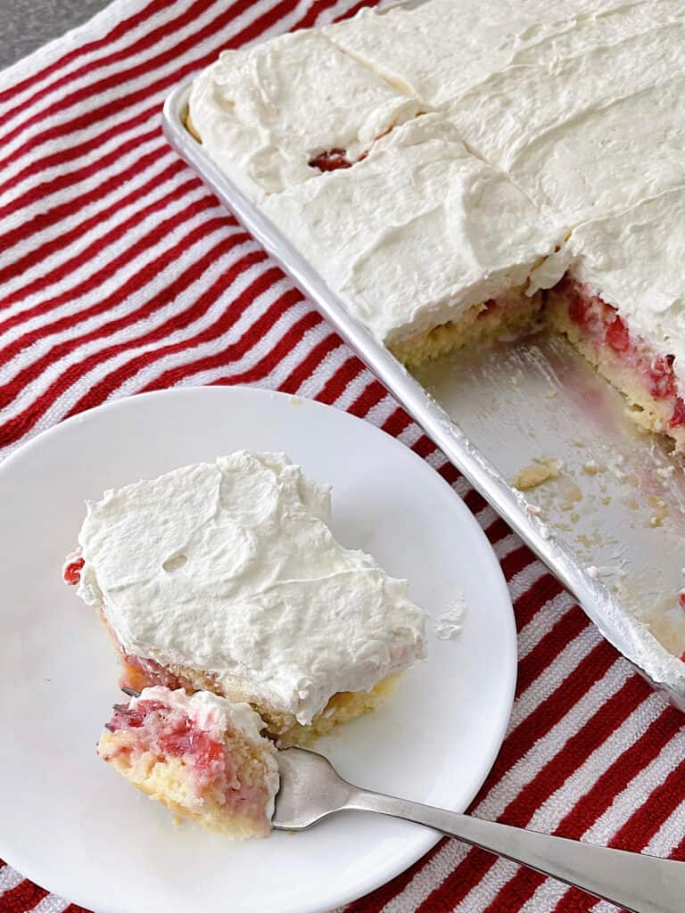 A slice of strawberry cream sheet cake.