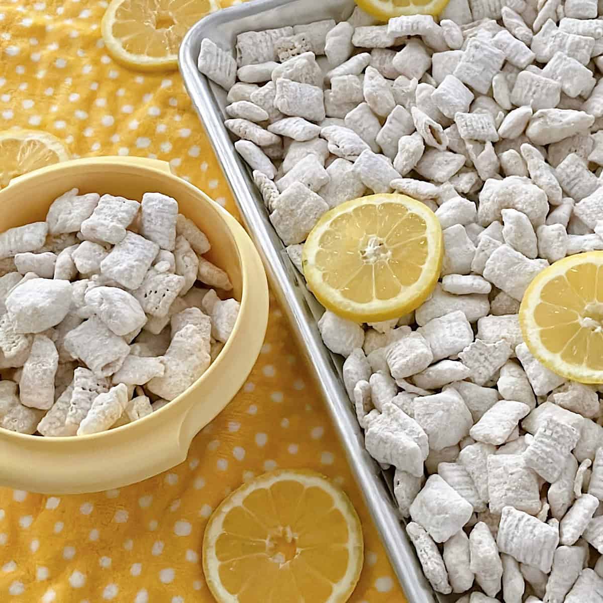 Lemon Pie Muddy Buddies in a yellow bowl and on a baking sheet.