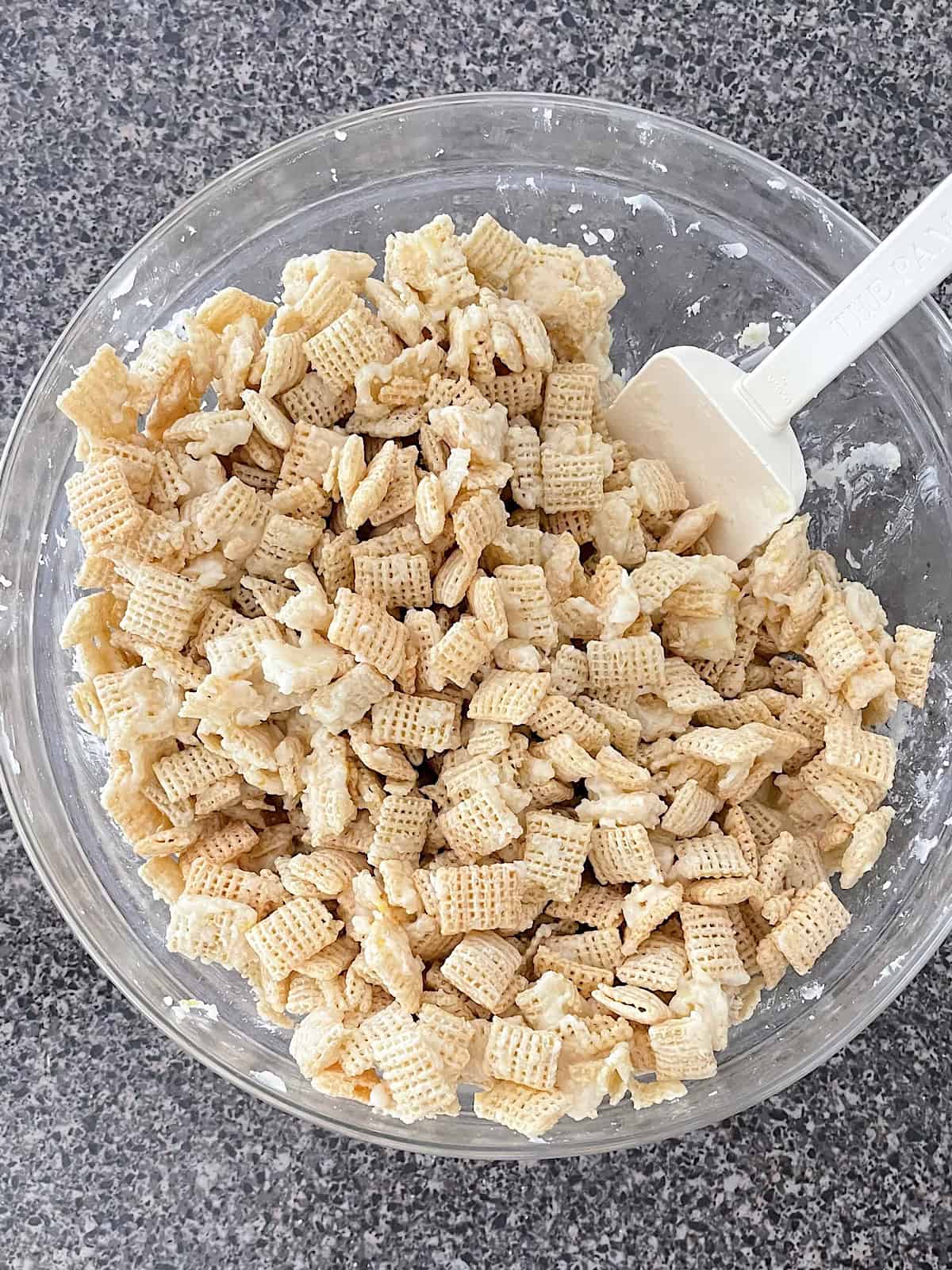 A bowl or rice chex covered in white chocolate.