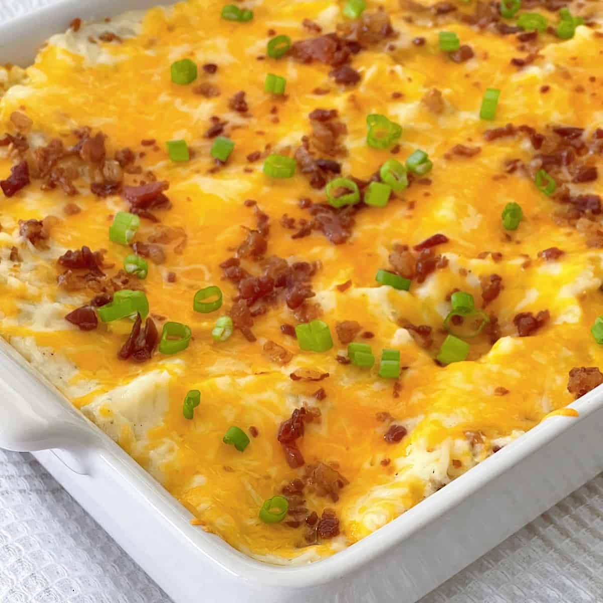 Twice Baked Potato Casserole in a white baking dish.