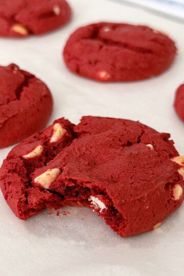 Red velvet cookies with white chocolate chips on parchment paper.